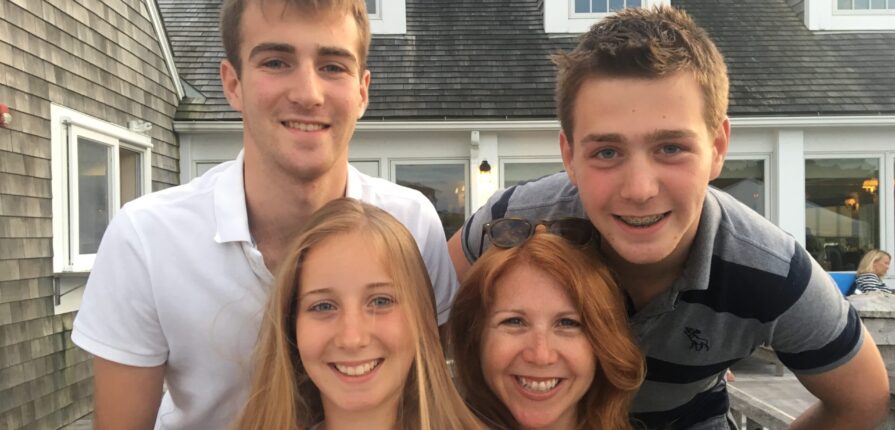 Jenny smiling together with her 3 kids (ages 10, 12, 14 at time of photo)